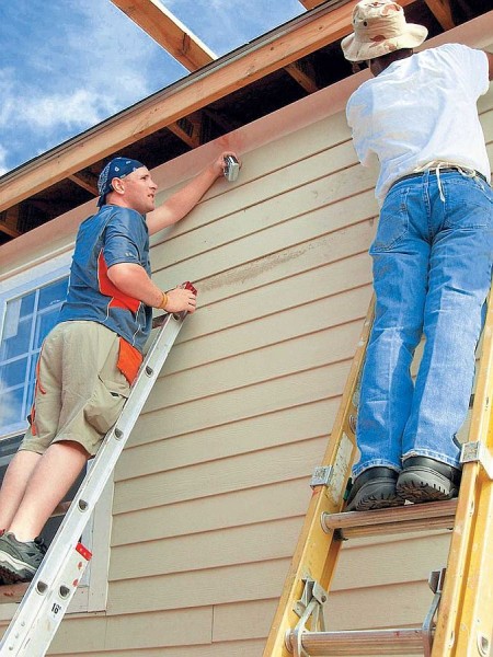 Pose de parement sur la façade d'une maison en bois