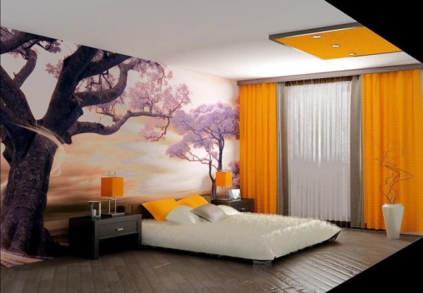 Photo murale dans la chambre au-dessus du lit, avec l'image d'un sakura en fleurs contre le coucher du soleil, à l'intérieur de la chambre