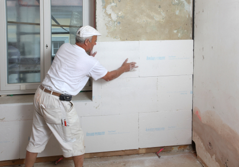 Sa larawan nakita namin ang proseso ng pag-init ng mga panloob na pader ng bahay na may mga sheet ng foam