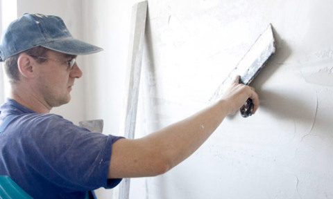 L'utilisation d'une large spatule pour le masticage des murs.